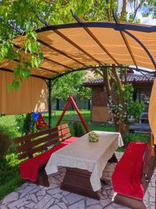 a picnic table and two chairs under a canopy at Villa Hills in Sarajevo
