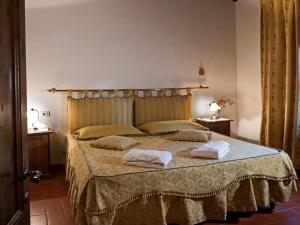 a bedroom with a bed with two towels on it at Pleasant Apartment with Swimming Pool,Garden,BBQ, Parking in Lucolena in Chianti