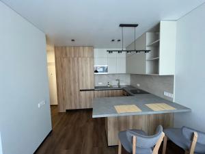 a kitchen with a counter and some blue chairs at Апартаменти La Familia в ЖК Республіка Rs113 in Kyiv