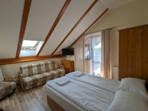 a bedroom with a bed and a couch and a window at Pokoje Gościnne Vip in Jantar