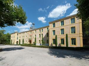 a large white building with trees in front of it at A beautiful 2 persons studio in a chateau with swimming pool in Montbrun-les-Bains