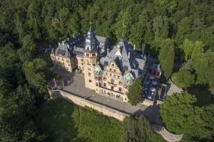 an aerial view of a large building with a clock tower at Schloss Hotel Wolfsbrunnen in Schwebda