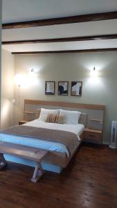 ein Schlafzimmer mit einem großen Bett und zwei Bildern an der Wand in der Unterkunft Casa Grande in Ghermăneşti