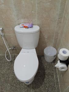 une salle de bain avec des toilettes blanches dans une chambre dans l'établissement Kayla Homestay, à Nusa Dua