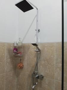 une douche avec pommeau de douche dans une salle de bain dans l'établissement Kayla Homestay, à Nusa Dua