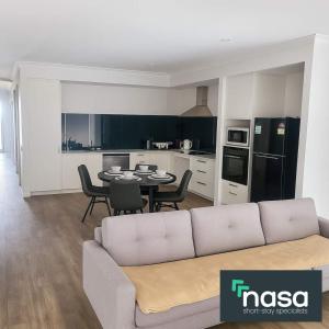 een woonkamer met een bank en een tafel bij Spacious Accessible with Bathrooms for Everyone in Alkimos