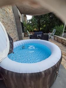 a large hot tub in a wooden barrel with a patio at Country house Koštela in Stankovci +23 photos