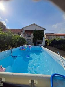 a large swimming pool with blue water in a yard at Country house Koštela in Stankovci
