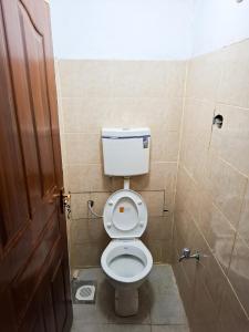 a small bathroom with a toilet and a shower at Maasai Boma Place - Studio Apartment in Juja