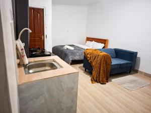 a living room with a couch and a sink at Maasai Boma Place - Studio Apartment in Juja
