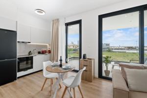 a kitchen and a living room with a table and chairs at Artemis 102 - Seaside Stories in Livadhia +25 photos