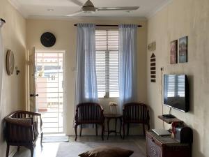 a living room with a table and chairs and a television at Yatie House in Malacca