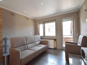 a living room with a couch and two windows at Attractive Apartment in Zell near River in Zell an der Mosel
