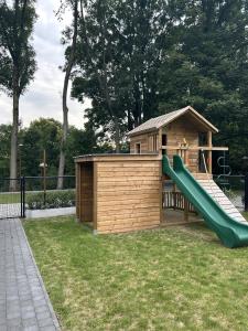 a playground with a slide and a building at Comfortabele groepswoning voor 8 met ruimte tuin in Turnhout