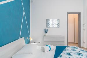 a bedroom with a bed and a blue wall at Le Quattro Perle Apartments in Pachino