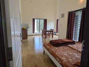 コダイカナルにあるZack's stone cottageのベッドルーム1室(ベッド1台付)、ダイニングルーム(テーブル付)