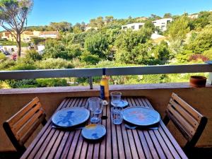 a wooden table with wine glasses on a balcony at Studio Le miroir à Saint Aygulf in Saint-Aygulf +29 photos