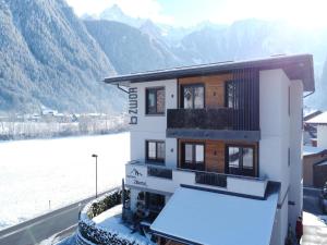 een gebouw met sneeuw op de grond naast een rivier bij Spacious Apartment near Ski Area in Mayrhofen in Mayrhofen