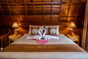 two swans made out of towels on a bed at Yama Villa & SPA Ubud in Payangan