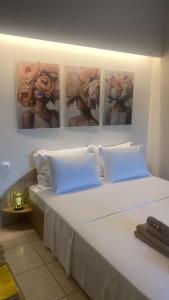 a bedroom with a large bed with four pictures on the wall at Central studio D1 Volos in Volos