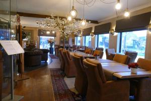 a restaurant with tables and chairs in a room at Hotel Monte Cristo in Hoeselt