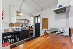 eine Küche mit einem Holztisch in einem Zimmer in der Unterkunft Ruapehu Cottage - Ohakune Holiday Home in Ohakune