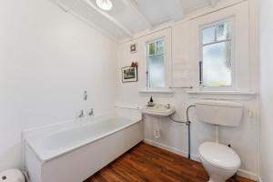 ein Badezimmer mit Badewanne, Toilette und Waschbecken in der Unterkunft Ruapehu Cottage - Ohakune Holiday Home in Ohakune + 18 Fotos