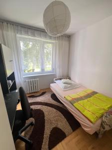 a small bedroom with a bed and a large window at Przytulne mieszkanie m3 Gorlice in Gorlice