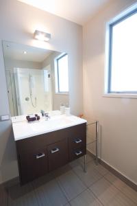 a bathroom with a sink and a large mirror at Bay Breeze Accommodation in Cooks Beach