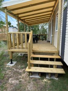 una terraza de madera en el lateral de una casa en Mobilhome Cap'Oceha SIBLU-Les Viviers 4étoiles, en Lège-Cap-Ferret