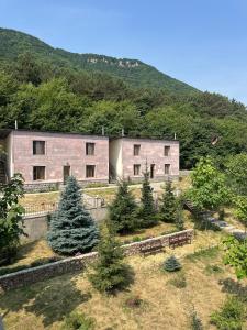 a building with benches in front of a mountain at Yeghevnut Hotel in Goris