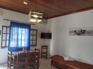 a dining room with a table and a couch at Litus Amoris in Sidari