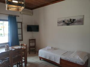 a bedroom with a bed and a desk and a television at Litus Amoris in Sidari +26 photos