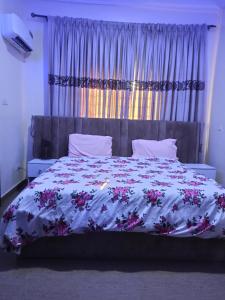 a bedroom with a large bed with flowers on it at Abimbola's - 3 Bedroom Apartment in Lagos