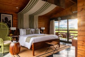 a bedroom with a bed and a large window at Rhino and River Wildlife Retreat & Spa, Pobitora - Guwahati in Pakariāmukh +134 photos
