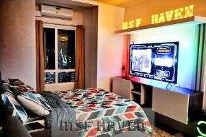 a bedroom with a bed and a tv on a wall at MSF Haven in Manila