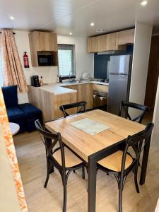 Una cocina y un comedor con mesa y sillas. en Mobilhome Cap'Oceha SIBLU-Les Viviers 4étoiles, en Lège-Cap-Ferret 13 fotos más
