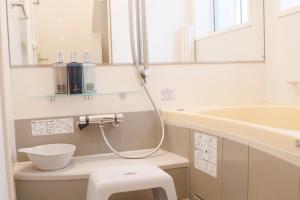 a bathroom with a toilet and a sink and a tub at Dori Dori House Ebisu in Tokyo