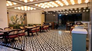 a restaurant with tables and chairs on a tiled floor at La Riviera Suites in Hyderabad