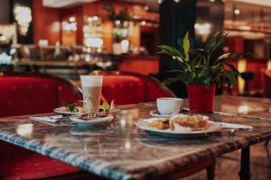 a table with plates of food and drinks on it at Park Hotel Diament Bielsko-Biała in Bielsko-Biala