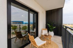 a balcony with chairs and a table with a view at One Bedroom Apartment by Otolo Homes with Free Yas Theme Park Tickets in Abu Dhabi
