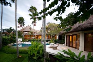 a house with a pool and a yard with palm trees at Planta Boutique Resort in Canggu