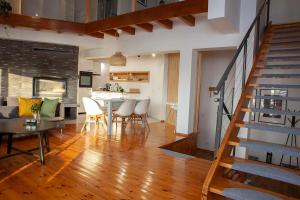 a living room with a staircase and a table and chairs at Apartamenty Jeziorna 40 in Charzykowy