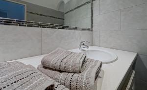 a white bathroom with a sink and a white sink at La Parenthèse Corse in LʼÎle-Rousse +3 photos