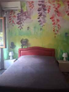 Un dormitorio con una cama y una pared con flores. en B&B Flora, en Aradeo
