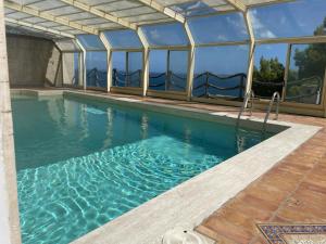 a swimming pool with glass windows and a swimming pooliterator at Rooms hub Torre di Cesare in Maiori