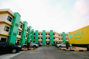 un gran edificio con coches estacionados en un estacionamiento en Go Hotels Bacolod, en Bacolod