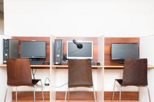 a computer desk with two monitors and two chairs at Barkly Backpackers in Melbourne