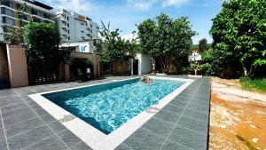 a swimming pool in front of a building at Lucky Phu Quoc Hotel in Phú Quốc