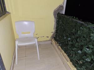 a white chair sitting in a room next to a plant at Sevian BnB in Kisumu